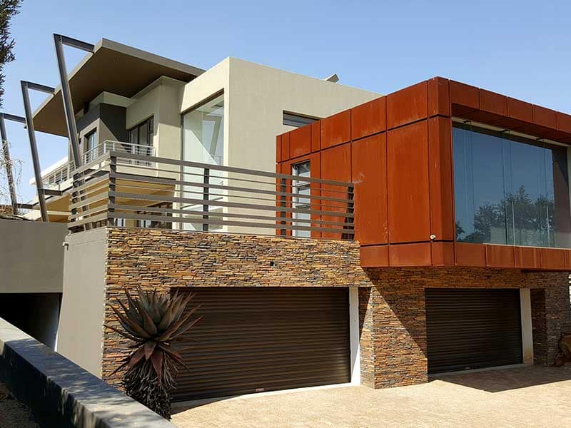 Decorative steel framework carrying a garden over a house entrance