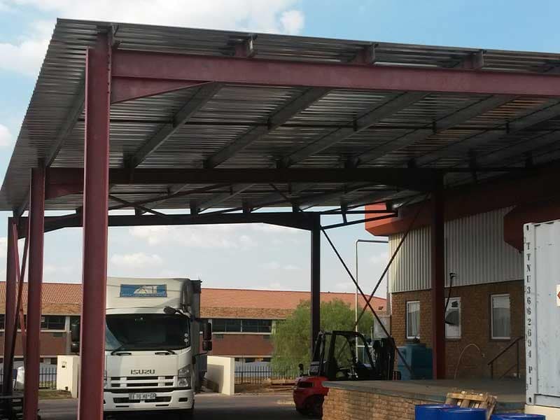 Covered steel drive-through loading bay extension to an existing warehouse