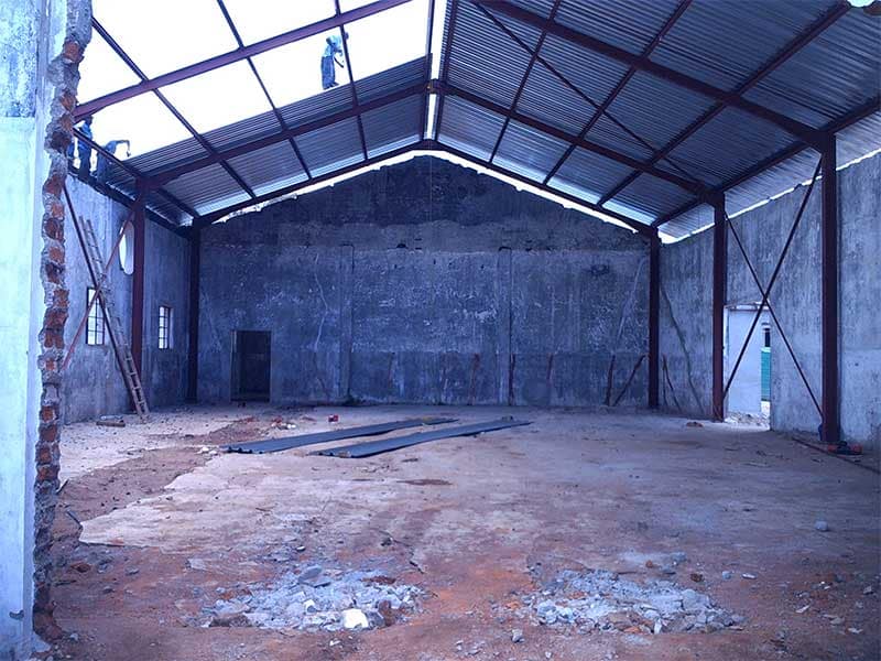 Steel overbuild structure erected over an existing damaged building in Mozambique