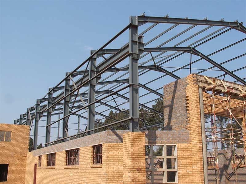 Steel portal frame structure with overhead crane rails mounted on the columns